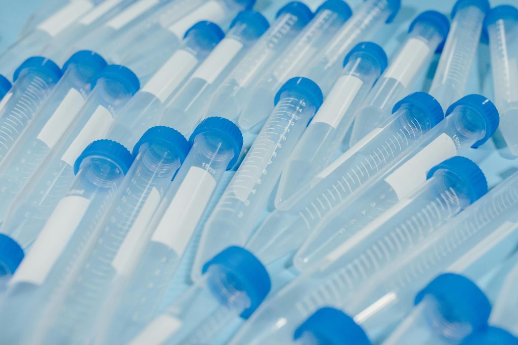 Close-up of blue-capped laboratory test tubes arranged in a pattern.